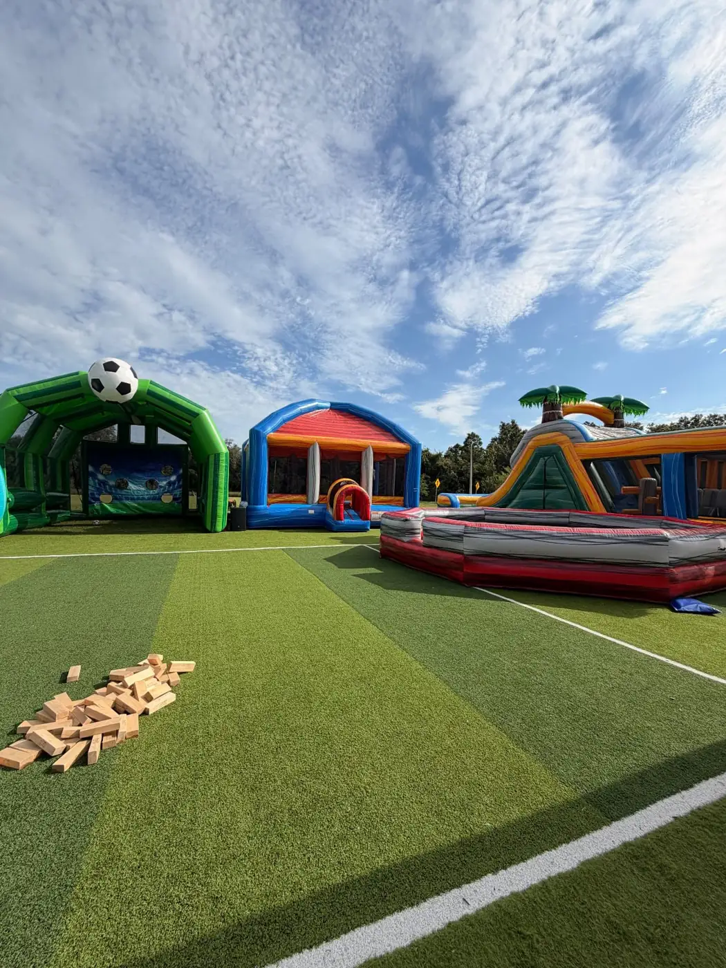 Several MJT inflatables set up across an outdoor event field