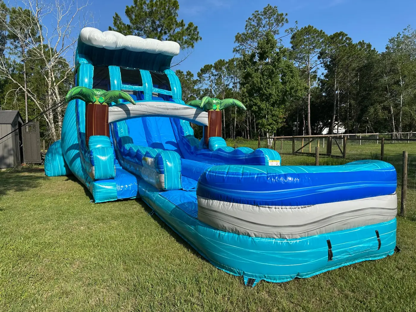 Turquoise water slide with a blue splash pool on grass