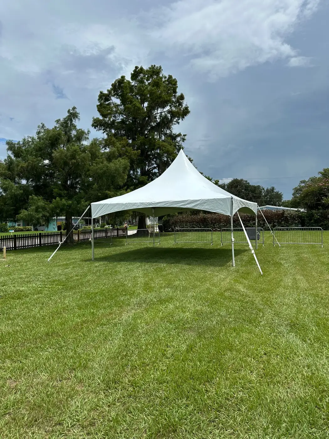 Open-sided white peaked tent on a spacious lawn