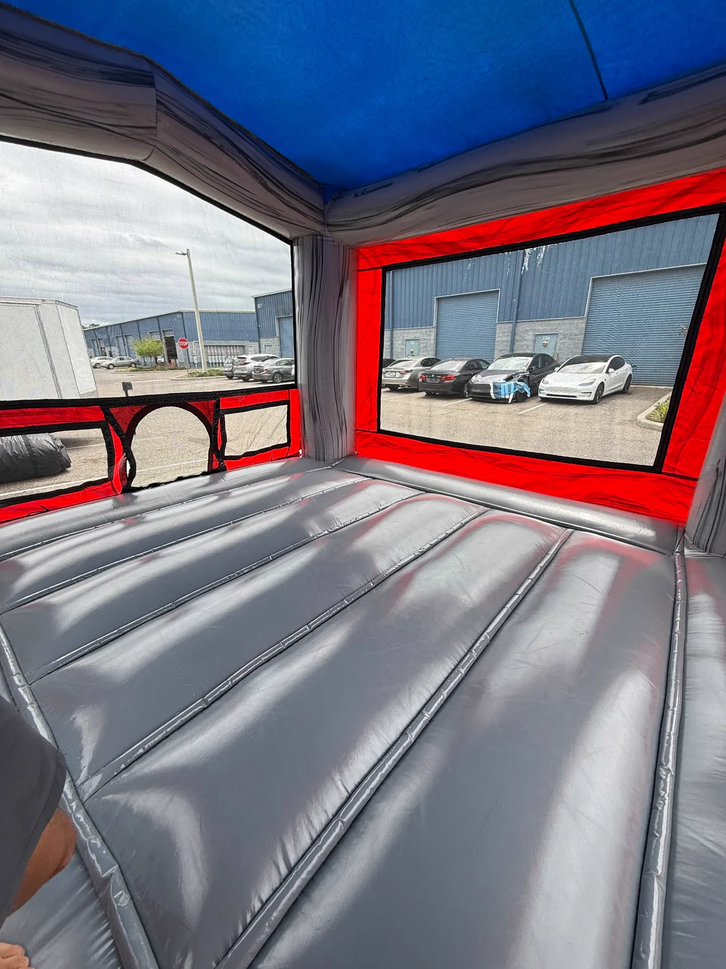 Inside a freshly cleaned bounce house, showing the jumping surface and mesh windows
