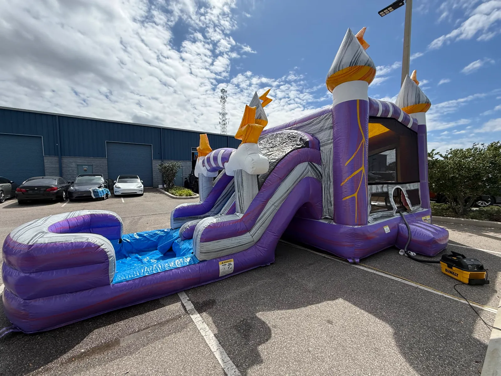 A purple castle combo bounce house with slide inflated at our warehouse for a full cleaning and safety check