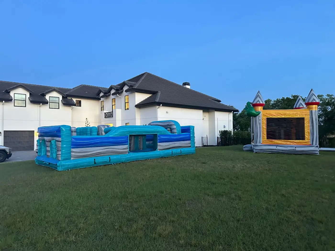 Blue inflatable obstacle course and bounce house in a backyard