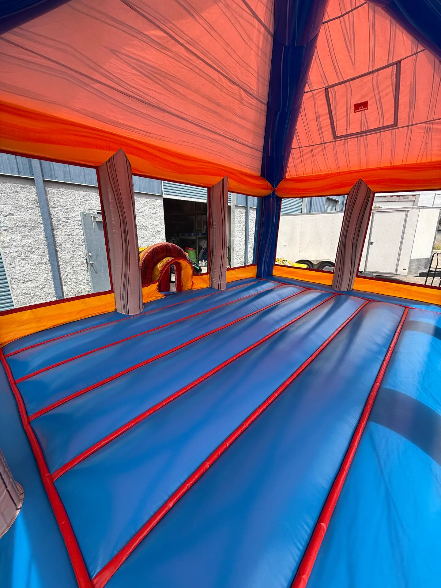 Inside a large inflatable during cleaning, showing the clean jumping surface and support columns