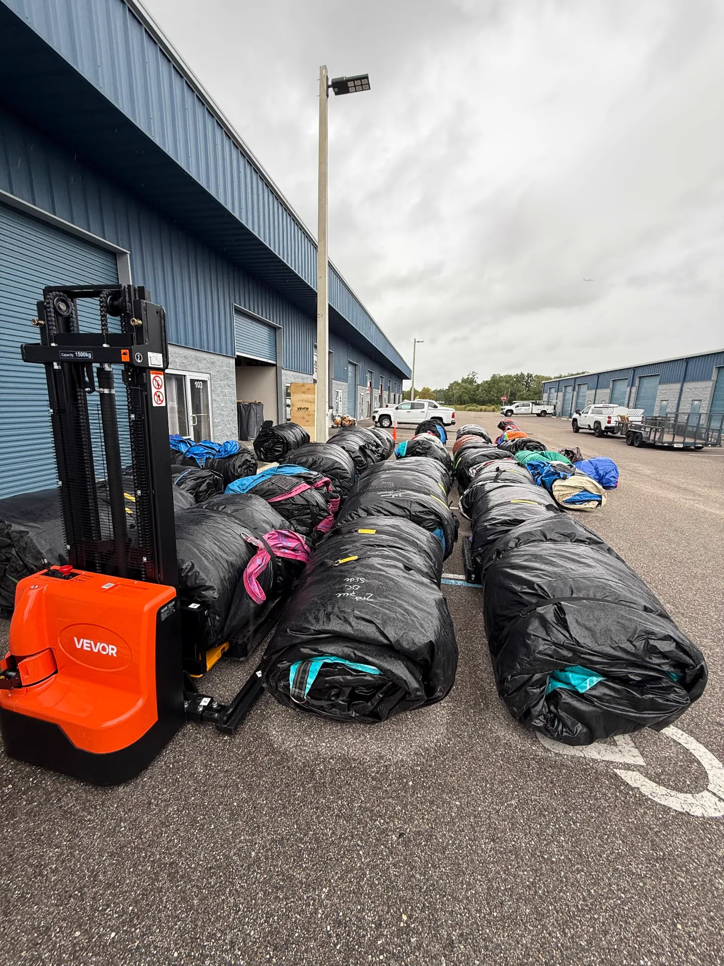 Our crew moving cleaned and rolled inflatables with a forklift at the Millers Jump Time warehouse