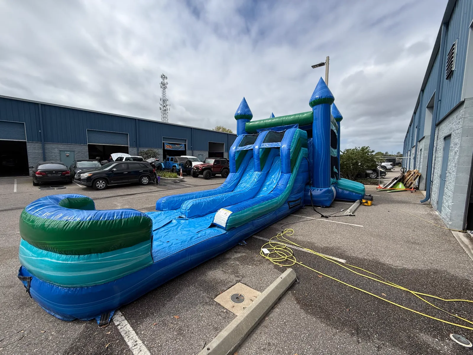 A blue and green water slide inflated at our warehouse for cleaning and inspection
