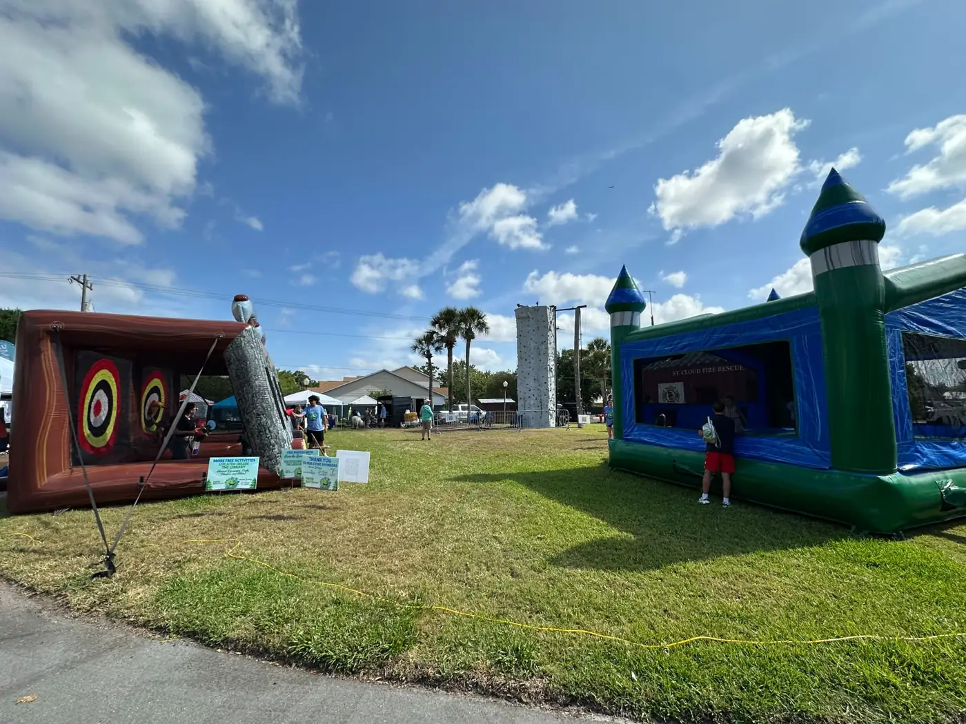 Inflatable target game and castle bounce house set up on grass