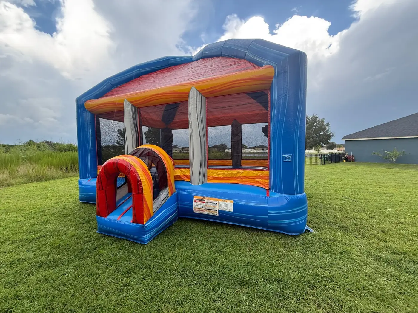 MJT blue and orange bounce house on grass