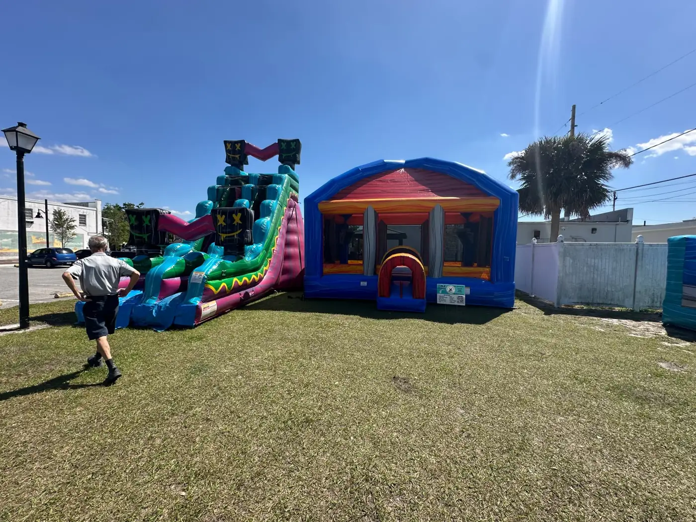 MJT water slide and bounce house arranged in a fenced yard